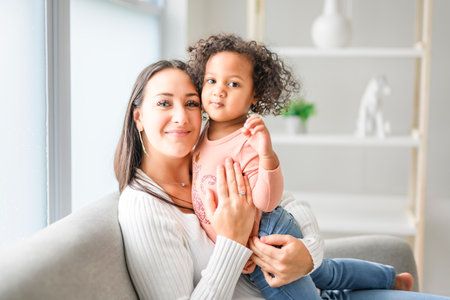 Mother with little daughter at home sofa
