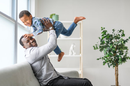 Happy Black American father with little boy at homeの写真素材