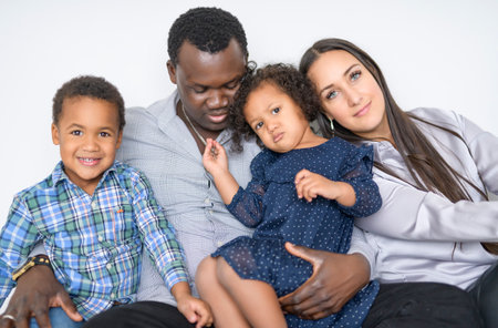 family with boy and girl child posing on photo shooting on white backgroundの写真素材