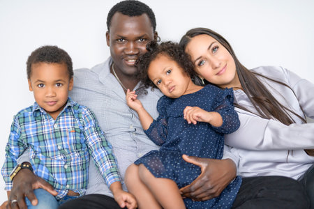 family with boy and girl child posing on photo shooting on white backgroundの写真素材