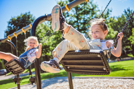 Happy 3 years old girl on a swing. Happy kid on playground