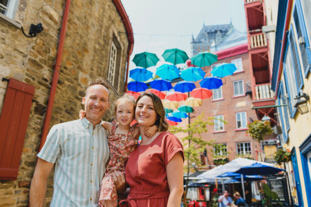 family in summer season in front of umbrella in quebec cityの写真素材
