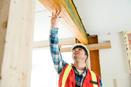 Inspector with white helmet inspecting an old house to be sure everything is well build checking the...