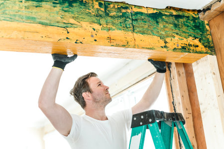Carpenter men working in an old house installing beam