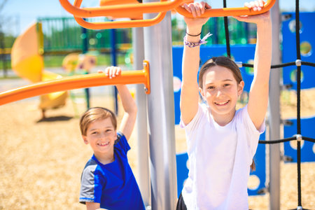 teenager girl and boy on a playground on summer day.