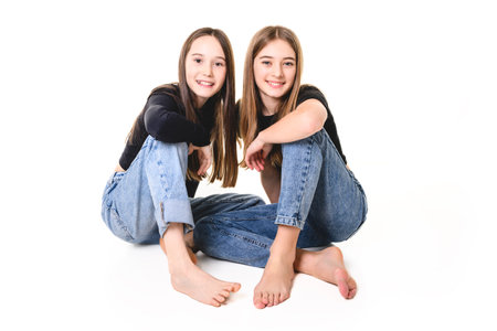 Two Young pre teen best friend girl on studio whiteの写真素材