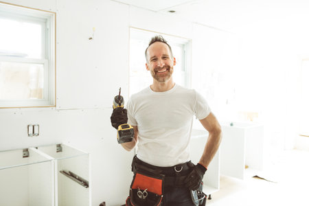 Carpenter Installing Luxury Modern Fitted Kitchen in houseの写真素材