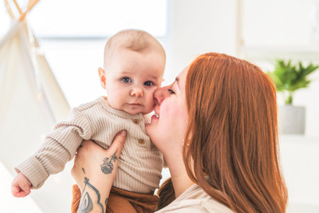 young beautiful mother with a baby boy on the play roomの写真素材