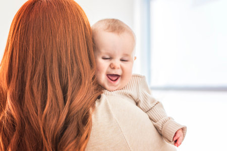 young beautiful mother with a baby boy at homeの写真素材