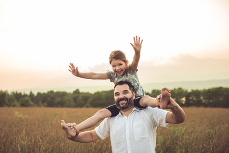 Happy family father with children daughter on nature sunsetの写真素材