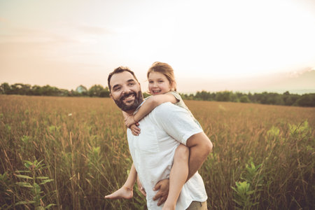 Happy family father with children daughter on nature sunsetの写真素材