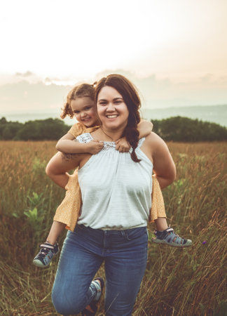 Happy family mother with children daughter on nature sunsetの写真素材