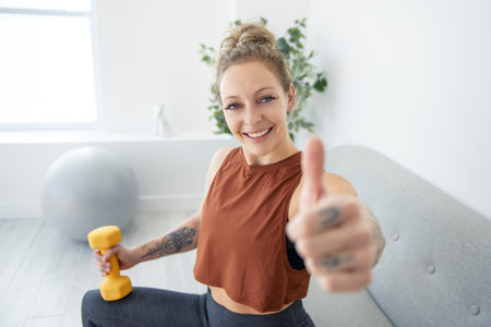 Training to become the best. A beautiful woman in sports clothing doing exercising at homeの写真素材