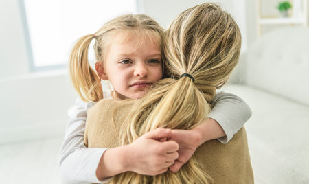 mother hugging and consoling little preschool frustrated girlの写真素材
