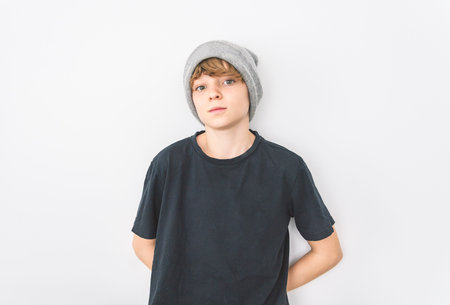 Teen boy in blank black wearing gray toque t-shirt, isolated on white background.の写真素材
