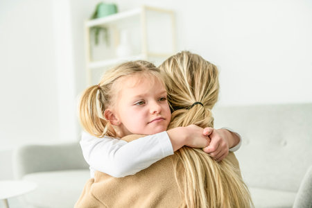 mother hugging and consoling little preschool frustrated girlの写真素材