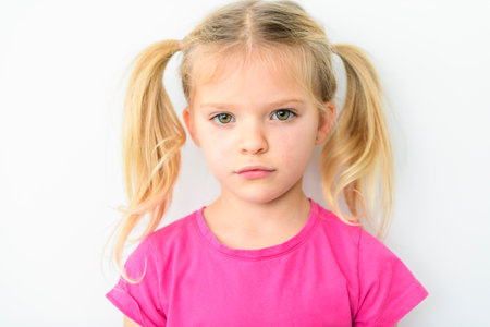 Isolated on white background portrait of little girl with blond hair and blue eyes.の写真素材