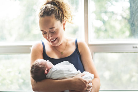 New born baby boy resting in mothers armsの写真素材
