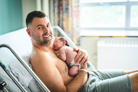 New born baby boy resting in father arms
