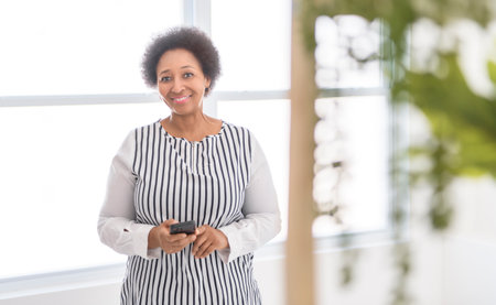 senior woman using her cellphone on white roomの写真素材