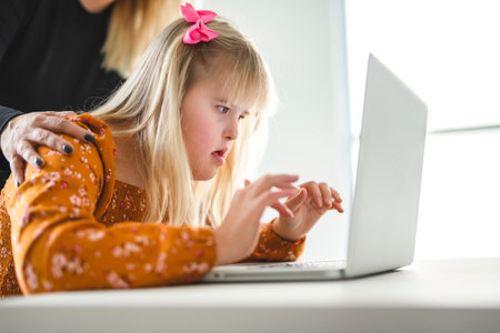 Girl with Down Syndrome doing homework at home, getting ready to go back to schoolの写真素材