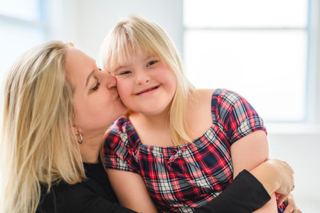 Mother and sweet down syndrome daughter girl at home sofaの写真素材