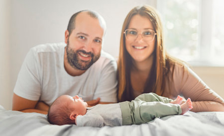father and mother on bedroom with his newborn baby sonの写真素材