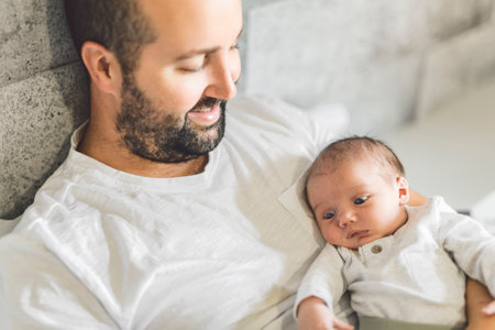 father on bedroom with his newborn baby sonの写真素材