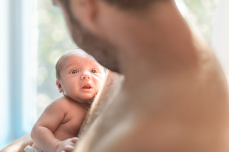 father on bedroom with his newborn baby son