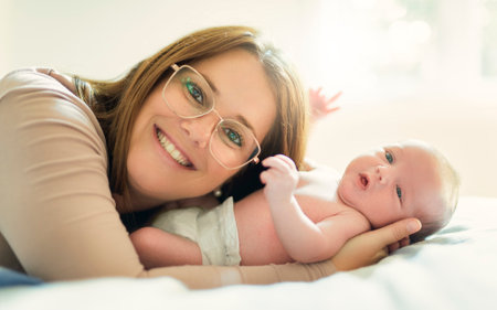 Mother on bedroom with his newborn baby sonの写真素材