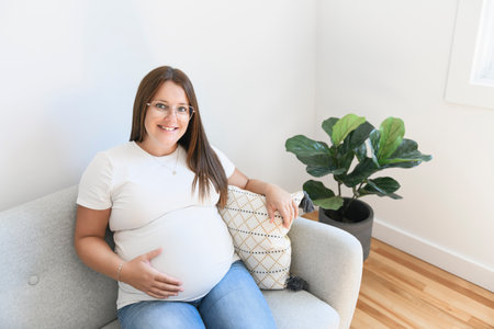 pregnancy, rest, people and expectation concept pregnant woman lying on sofa at homeの写真素材