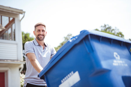 Caucasian Man is Walking Outside His House in Order to Take Out recyclingの写真素材