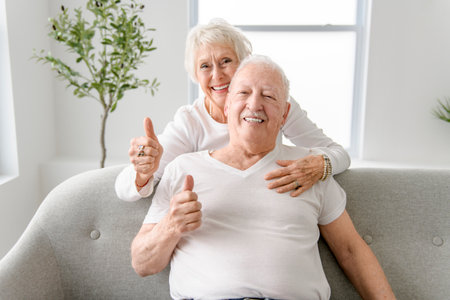 senior retired couple having great moment together on cozy sofa in living room.の写真素材