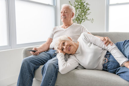 senior retired couple having great moment together on cozy sofa in living room.の写真素材
