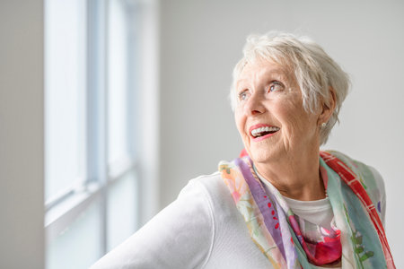 senior lady posing at home portrait close to a windowの写真素材