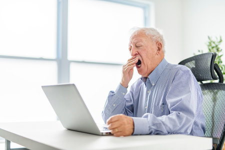senior men using a laptop while sitting at the officeの写真素材