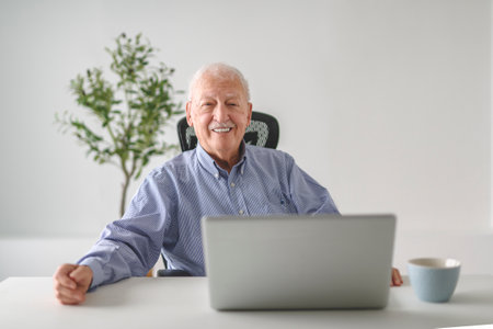 senior men using a laptop while sitting at the officeの写真素材