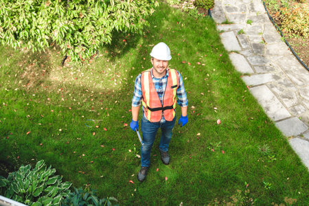 man with hard hat standing in front of a house to inspect