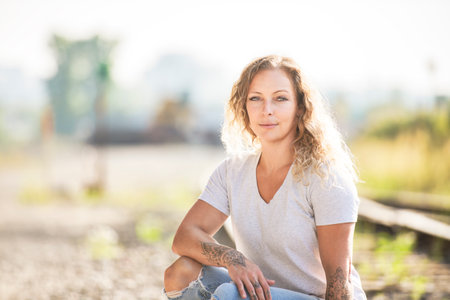 portrait caucasian woman stands outside on industrial backgroundの写真素材