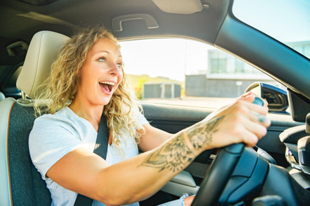 Portrait of joyful woman driving a car and having funの写真素材