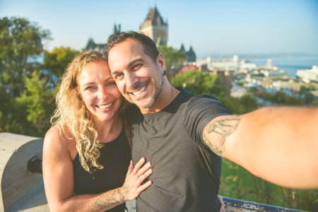 Quebec summer travel tourists couple in front of Frontenac Chateau, Old Quebec.の写真素材