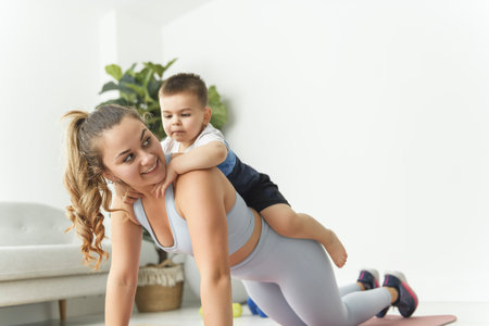 Sport Activities With Baby. Young Mom Exercising With Her Infant Son At Homeの写真素材