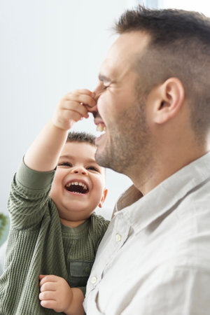 Mature father with small son on sofa indoors, resting.の写真素材