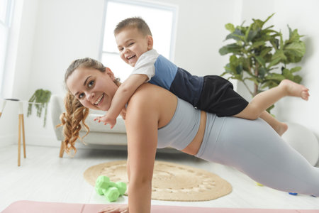 Sport Activities With Baby. Young Mom Exercising With Her Infant Son At Homeの写真素材