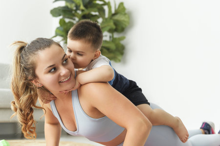 Sport Activities With Baby. Young Mom Exercising With Her Infant Son At Homeの写真素材