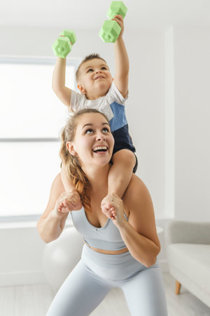 Sport Activities With Baby. Young Mom Exercising With Her son At Homeの写真素材