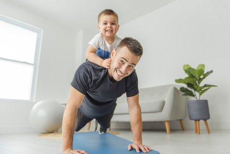 Little boy child having workout together with his father, exercising with dumbbells at homeの写真素材