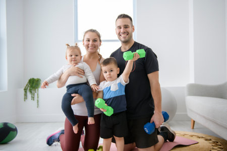 Portrait of happy healthy fit young family with little children standing togetherの写真素材
