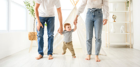 little baby boy first steps with the help of parent