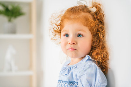 Little cute girl in a dress with redhead. The child is 2 years old.の写真素材